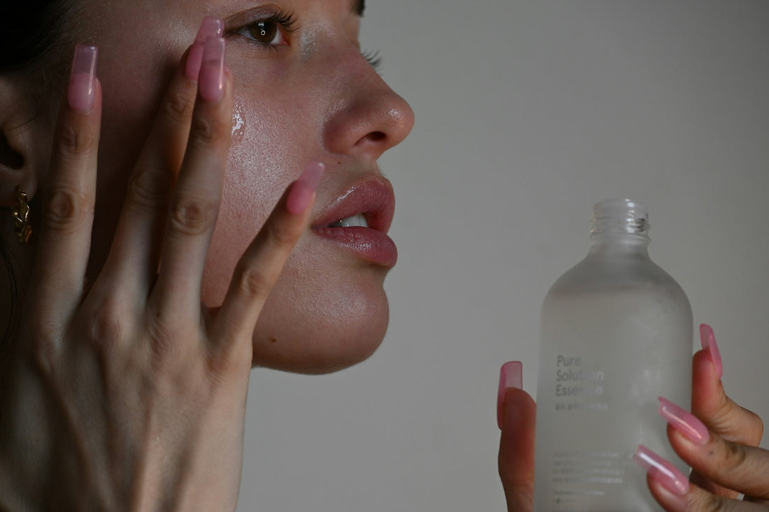 Model applying vitamin C skincare serum to the skin
