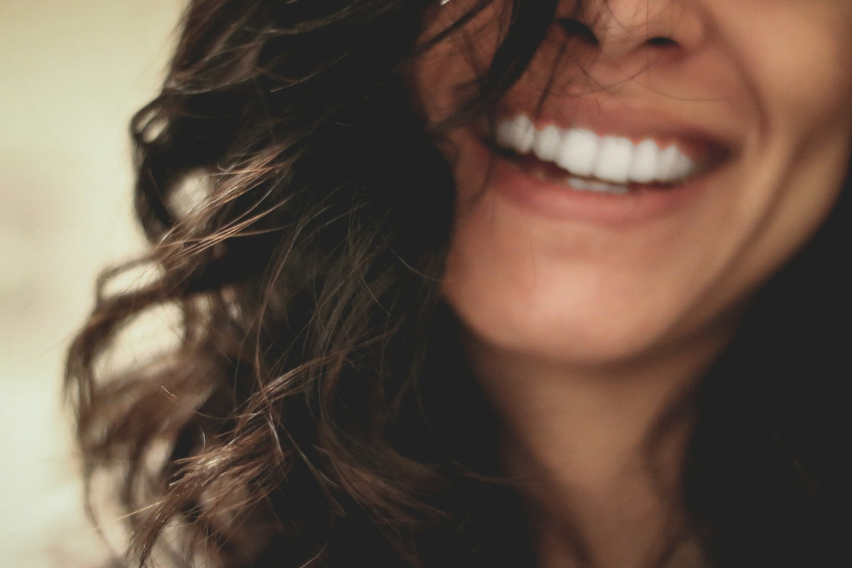 Bright, joyful portrait of a smiling woman with radiant skin for Dr. Walaa Beauty homepage banner